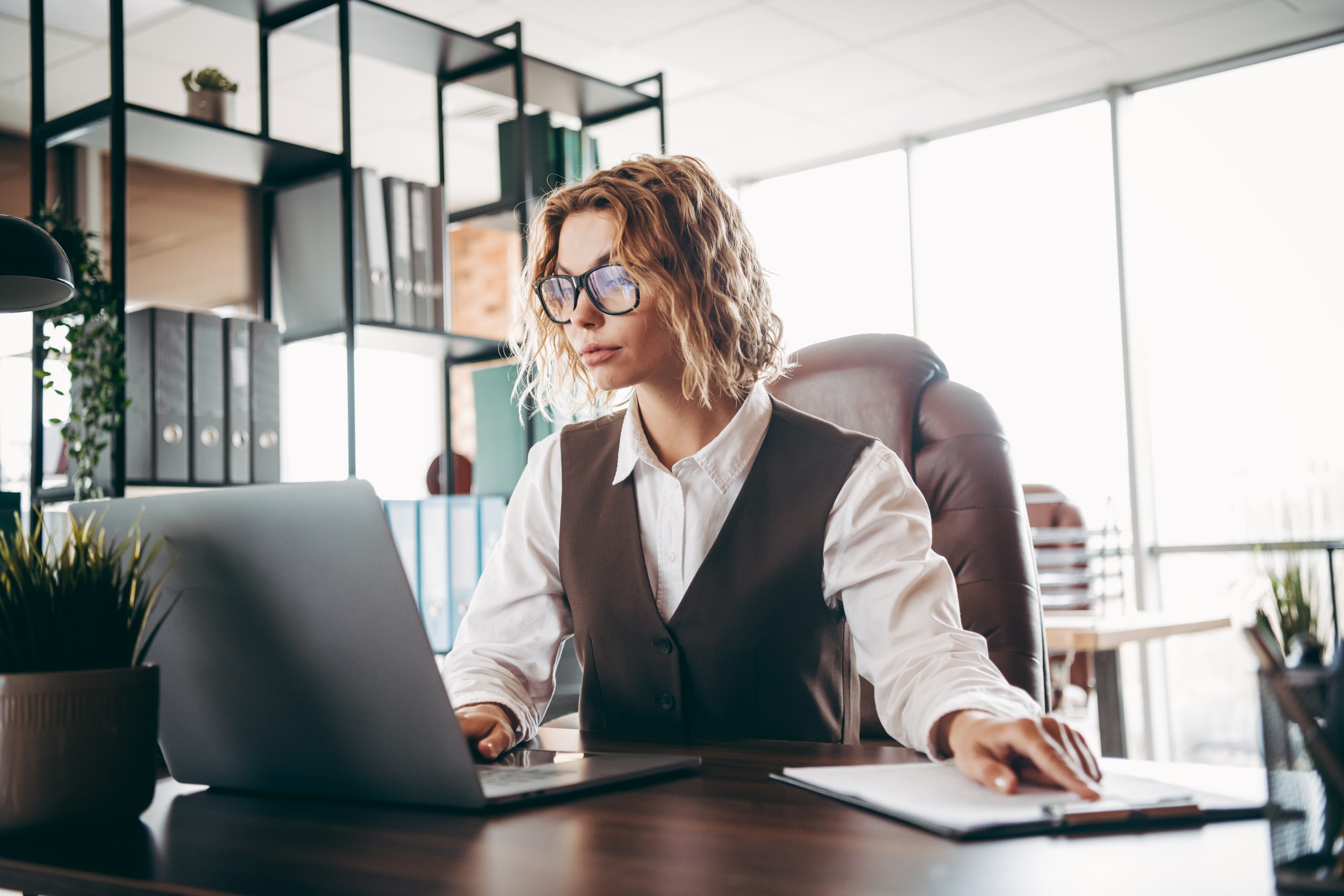 Conseillère en gestion de patrimoine travaillant sur ordinateur dans son bureau