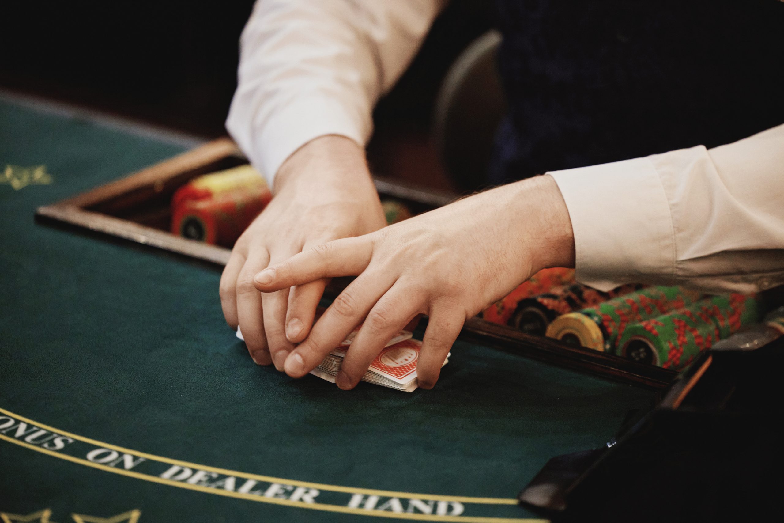 Mains de joueur de poker sur tapis de casino